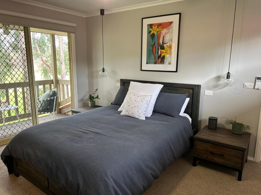 une chambre avec un lit avec des oreillers dessus dans l'établissement Modern townhouse, walking distance to town centre, à Yarra Glen