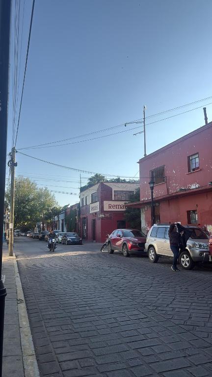 a group of people walking down a street with cars at Casa Paty in Oaxaca City
