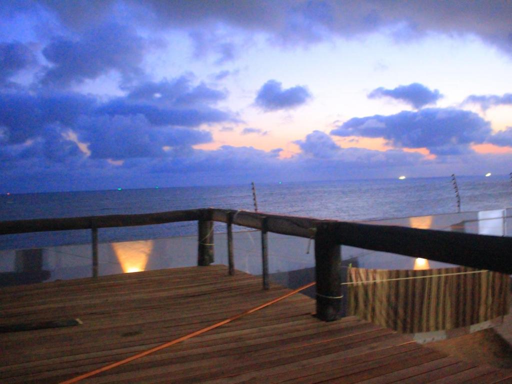 una terraza con vistas al océano al atardecer en MiHOTEL MONTE VILLAGE, en Beira