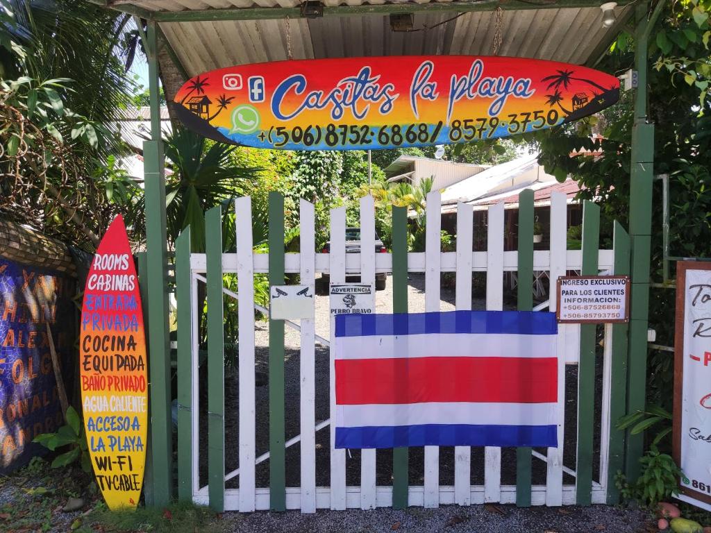 a white fence with a surfboard on top of it at Casitas La Playa in Puerto Viejo