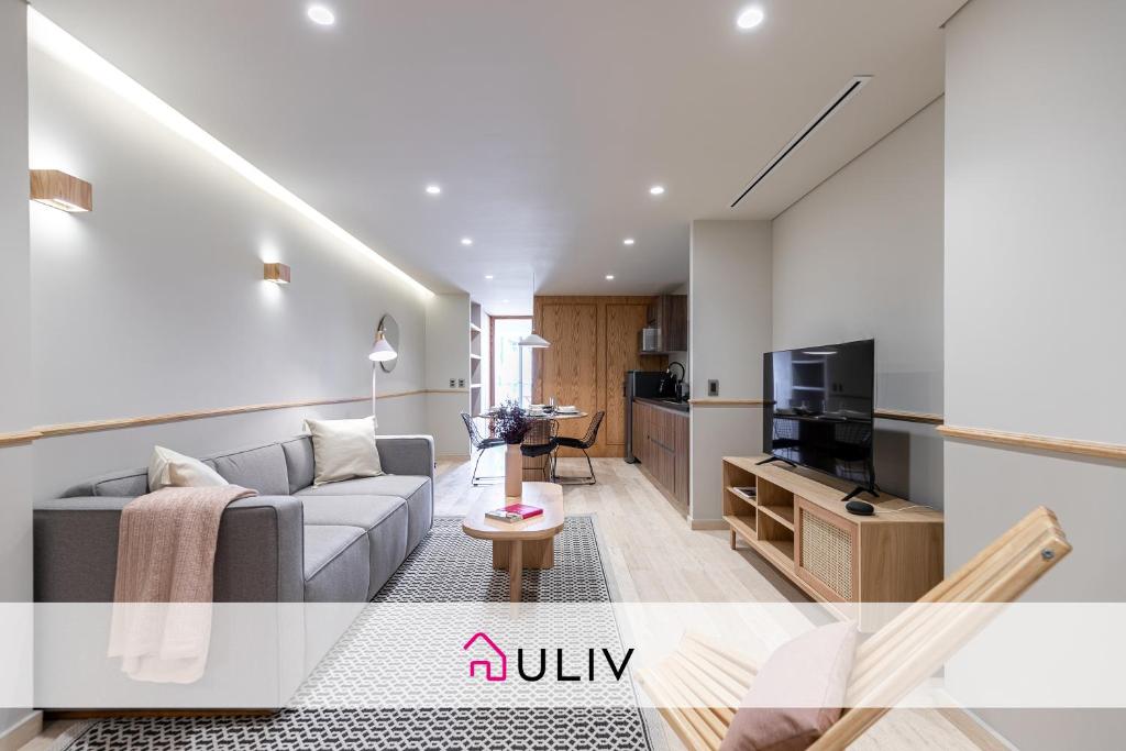 a living room with a couch and a tv at ULIV Antara in Mexico City