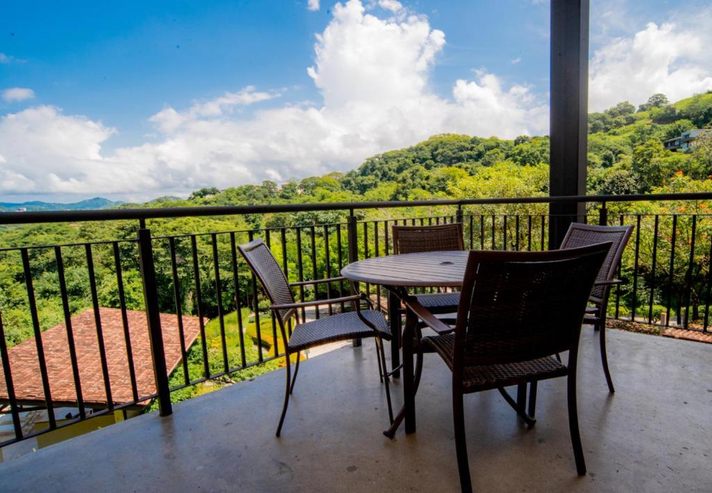 a table and chairs on a balcony with a view at A10- Roble Sabana 201 in Playa Conchal