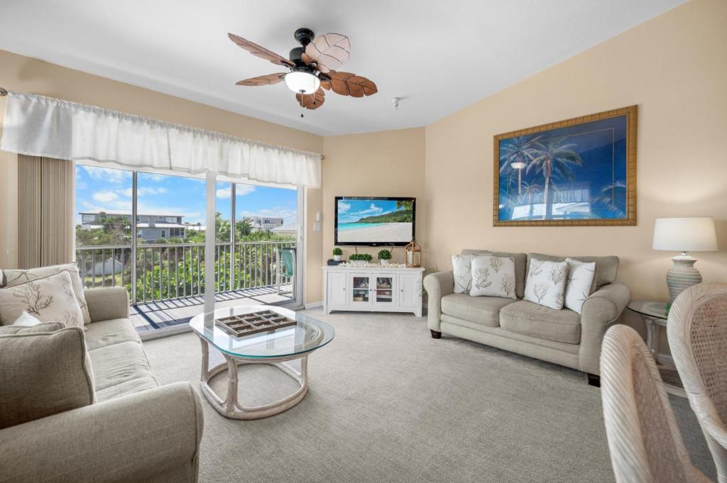 una sala de estar con un sofá y una mesa en Gulf Sands – 3BR Steps to Pool & Private Beach, en Punta Gorda Beach