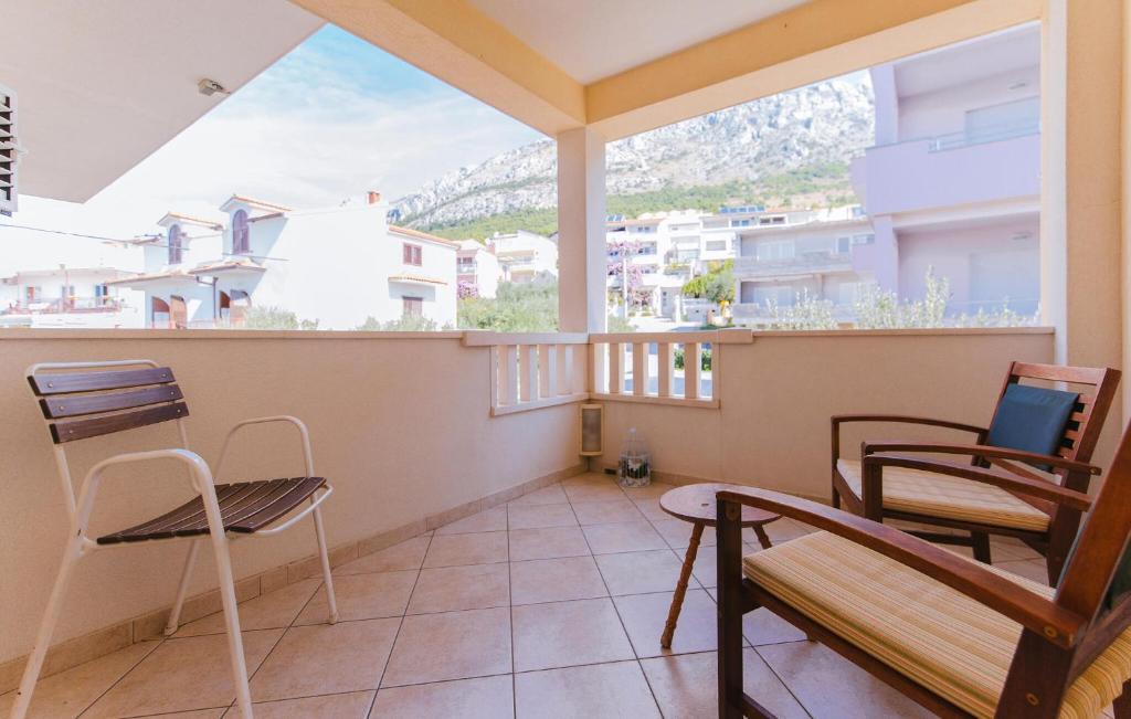 a balcony with two chairs and a laptop on it at Cozy Apartment In Omis With House Sea View in Tice