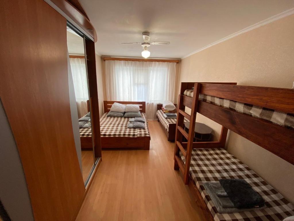 a small room with two bunk beds and a mirror at 3-badroom flat near the sea with 12 places to sleep in Sychavka