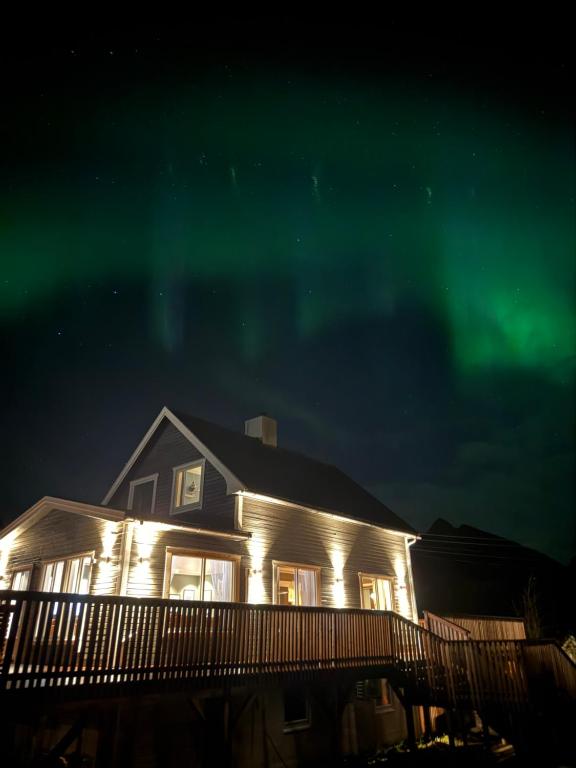a house with the aurora lights up at night at KB Villa - Panoramic view in Sørvågen
