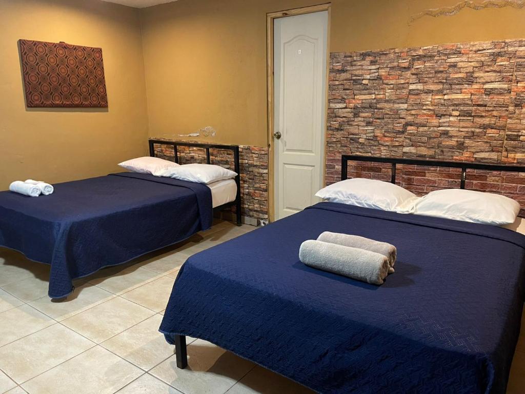 Alto BoqueteにあるLegado Residenceのレンガの壁、ベッド2台が備わるベッドルーム1室が備わります。