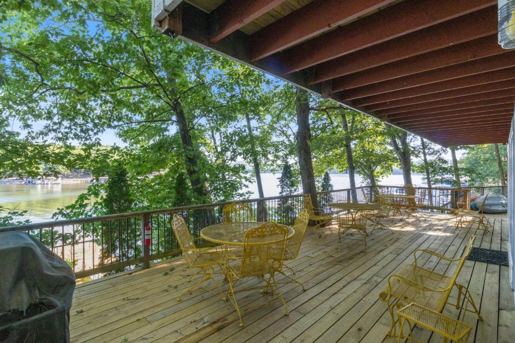 eine Terrasse mit einem Tisch, Stühlen und Bäumen in der Unterkunft Firepit, Kayaks, Paddle Board, Lake Views, Great Location in Purvis