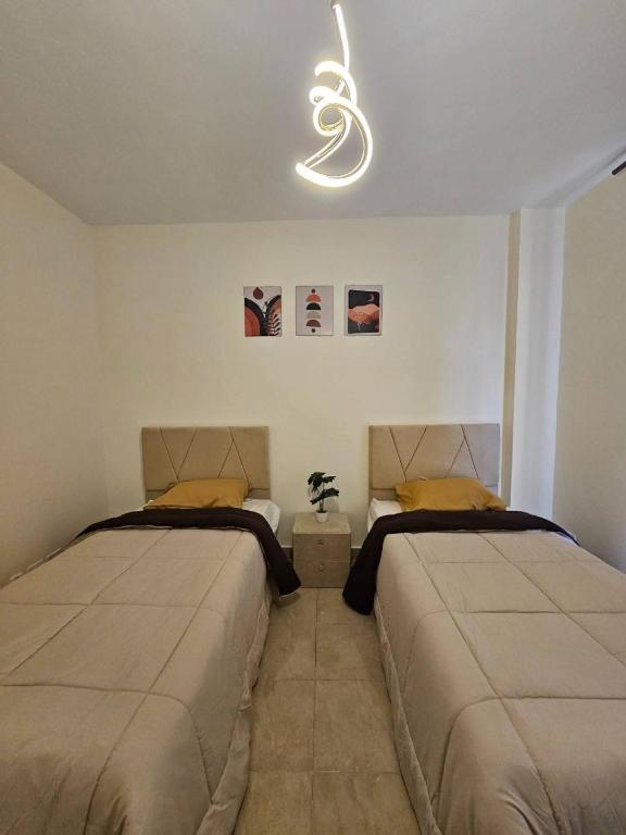 a bedroom with two beds and a light at Petra entrance Apartment in Petra
