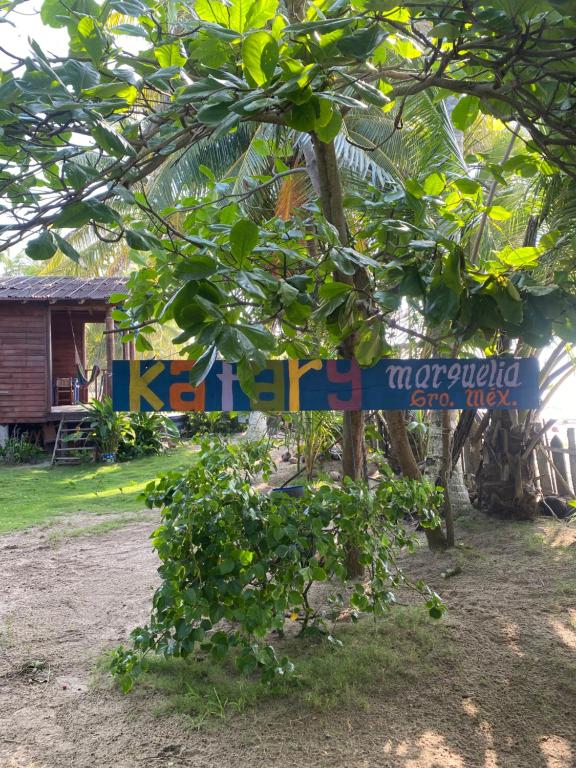 a sign on a tree in front of a house at Katary Gro in Marquelia