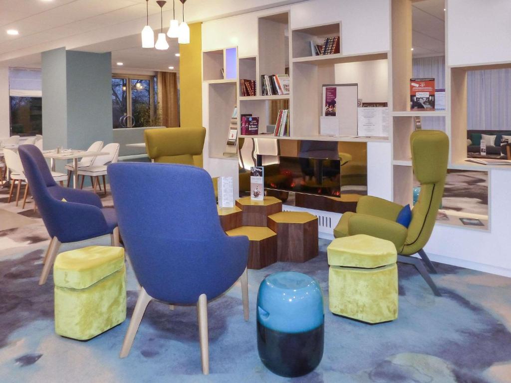a waiting room with chairs and a table at Hôtel Mercure Mâcon Bord de Saône in Mâcon