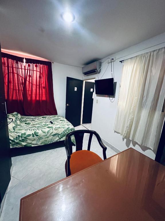 a small room with a table and a bed at Habitacion privada cerca al hospital de Neiva con Aire Acondicionado y baño Privado in Neiva