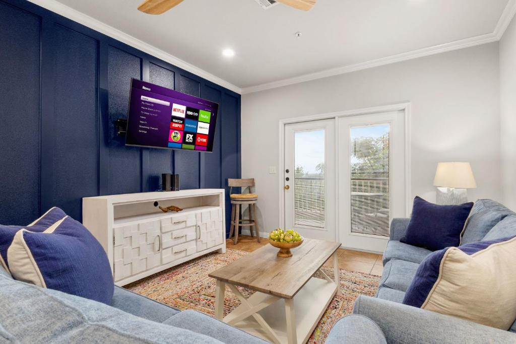 a living room with blue walls and a tv at Close to River Shared Family Pool Wurstfest Ready in New Braunfels