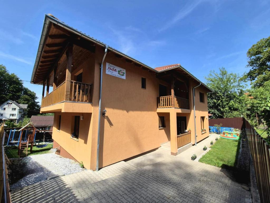 a house with two balconies on the side of it at Pensiunea NikoBella Panzió in Sovata