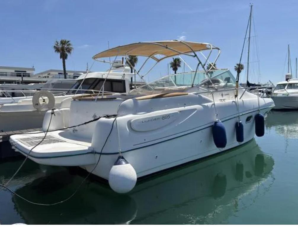 a white boat is docked in a harbor at Barco Marina de Cascais in Cascais