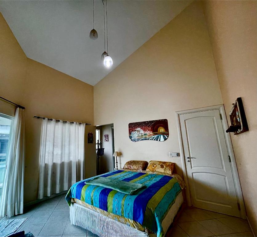 a bedroom with a bed with a colorful comforter at A Pérola do Gravatá in Navegantes