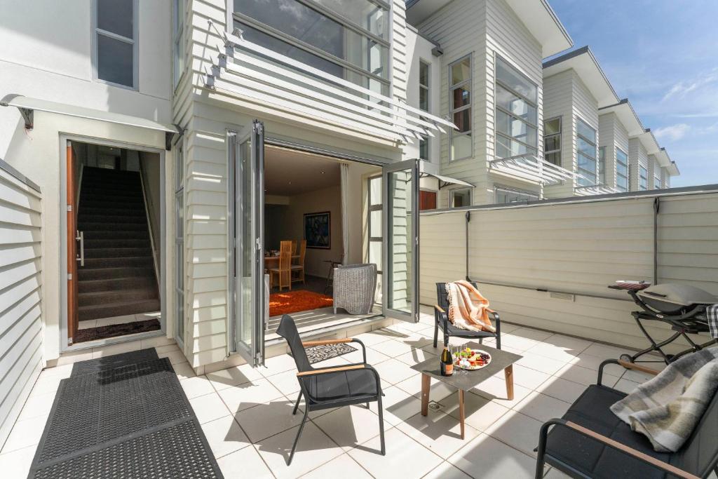 a patio with chairs and a table in front of a building at Stay Central Taupo in Taupo