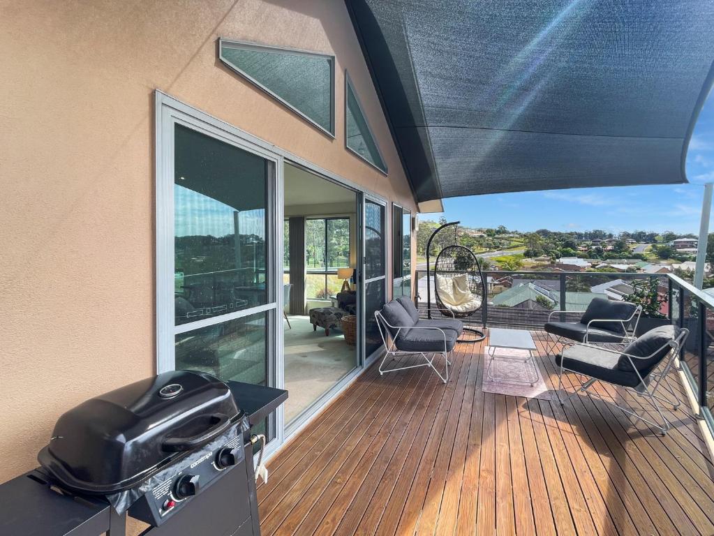 a patio with a grill and chairs on a deck at Beachside Retreat with Garage Parking in Surf Beach