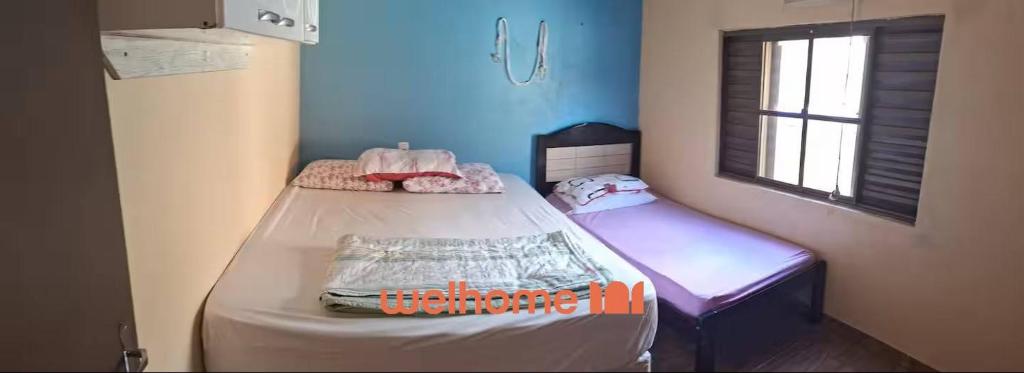 een kleine kamer met twee bedden en een raam bij Casa em Chapeco com Piscina e Vista da Montanha in Nonoai