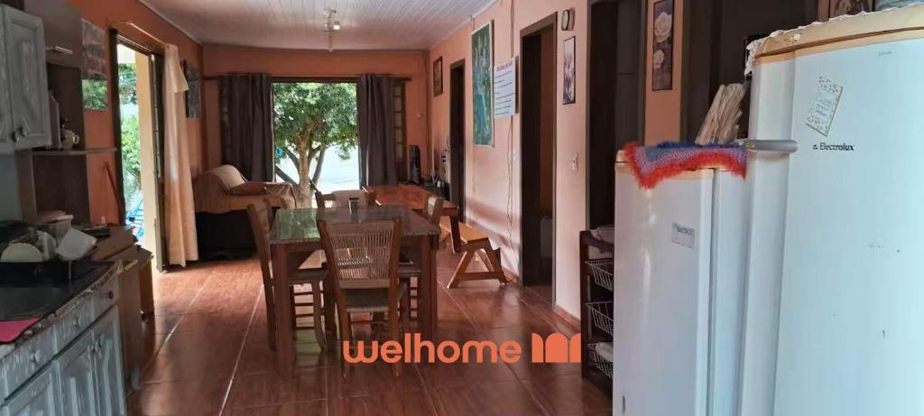 a kitchen with a refrigerator and a table and chairs at Casa em Chapeco com Piscina e Vista da Montanha in Nonoai