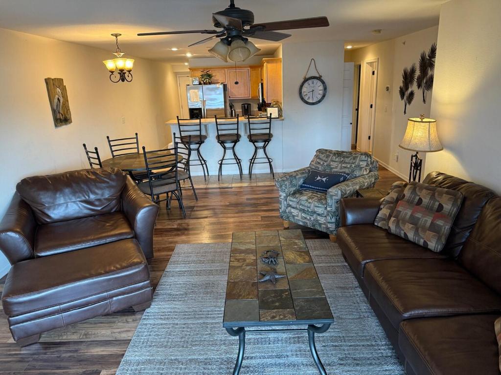Una sala de estar con sofás de cuero y una mesa. en Lake Front and Calm Waters at Miramar 3BR 2BA, en Camdenton