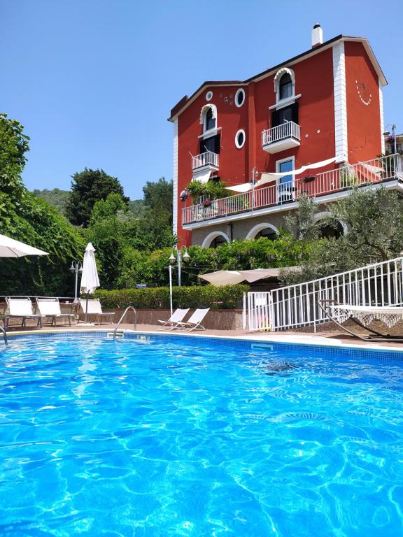 una gran piscina frente a un edificio rojo en Villa Elvira, en Pellezzano