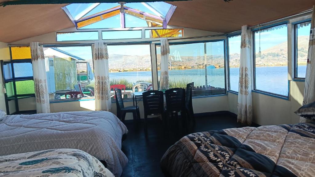a bedroom with two beds and a view of the water at cabañas del inka in Puno