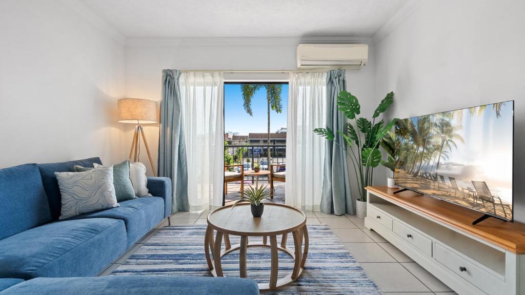 Una sala de estar con un sofá azul y una mesa. en Urban Getaway on Grafton, en Cairns