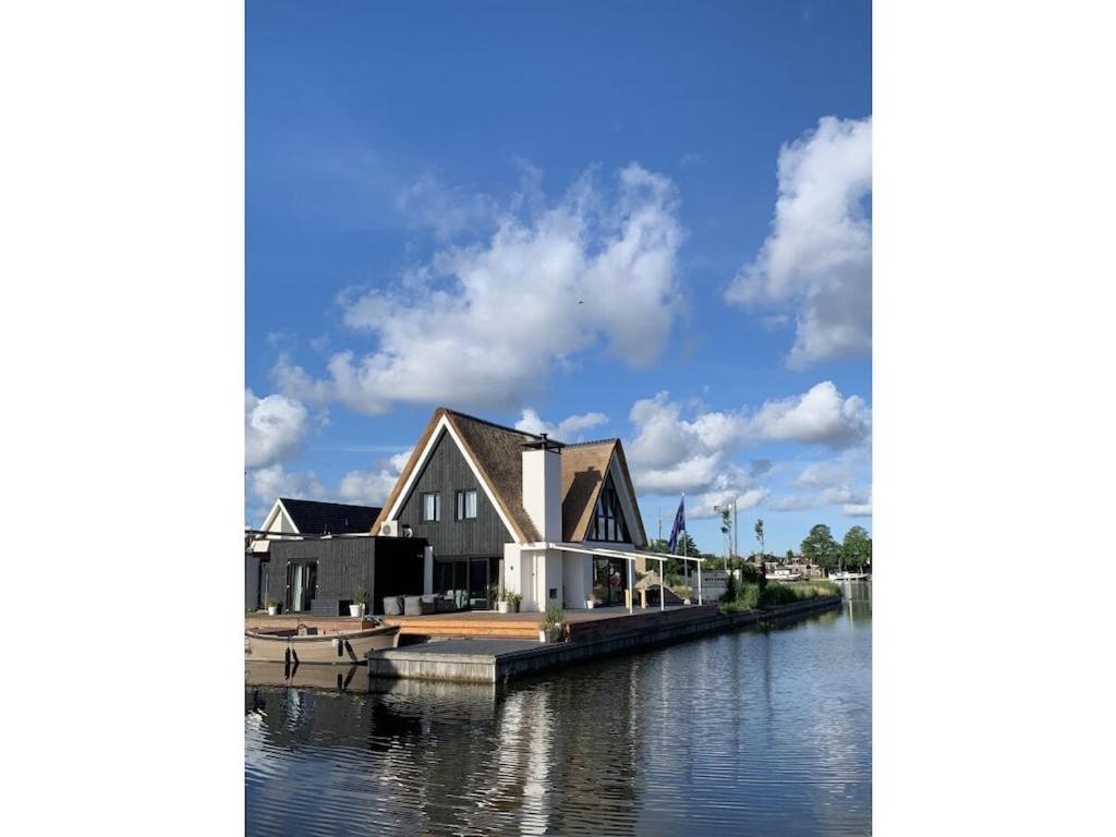 a house on a dock on a body of water at by the water in Friesland NI in Stavoren