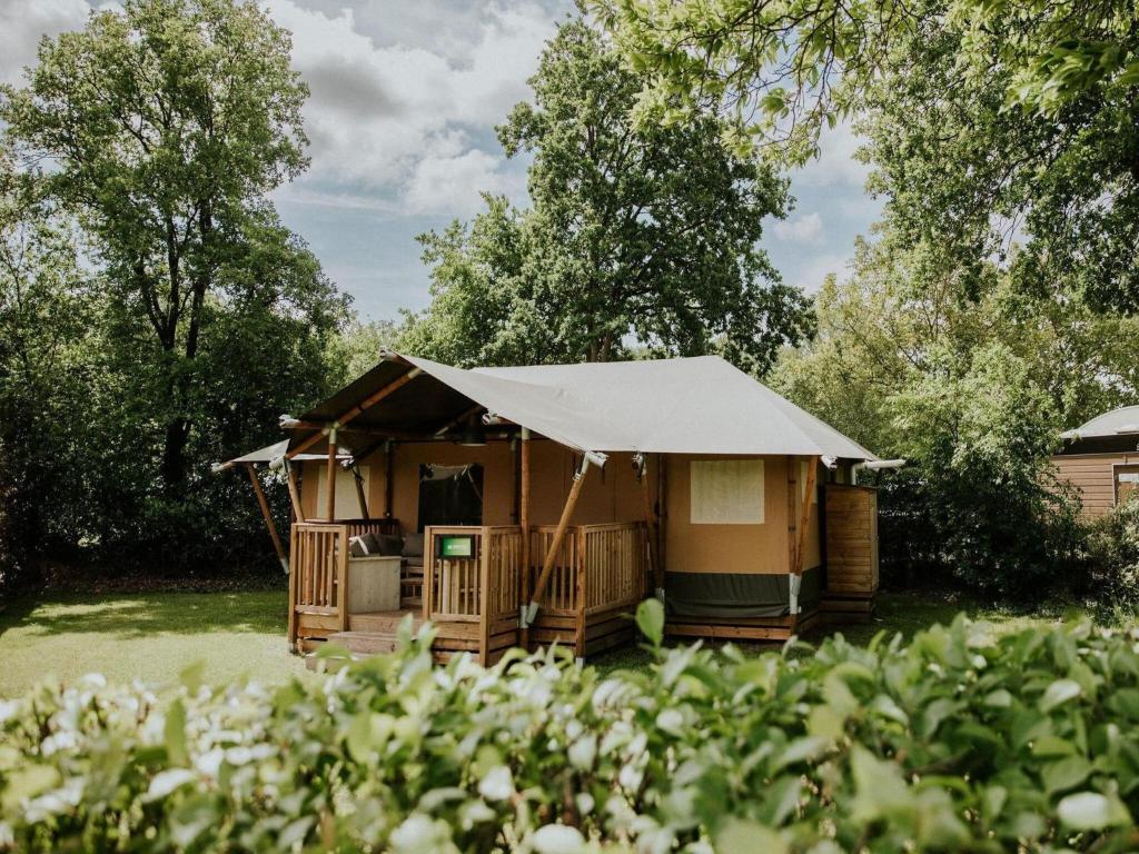 a yurt with a canvas roof in a garden at Luxury Family Tent with Play Area in Balkbrug