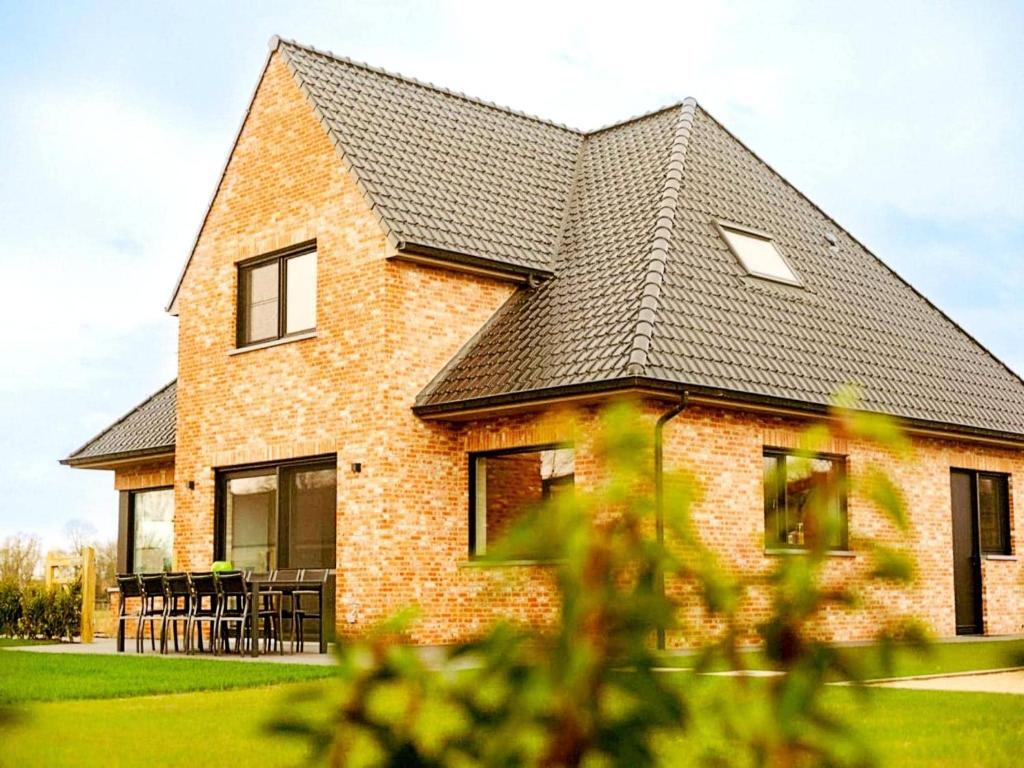 a brick house with a black roof at Luxury holiday home in Zwevezele in Lichtervelde