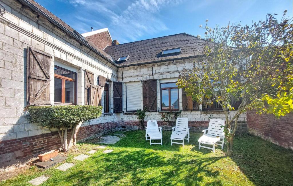 Un patio con dos sillas y una casa. en Gite De Campagne Avec Jardin, en Mailly-Maillet