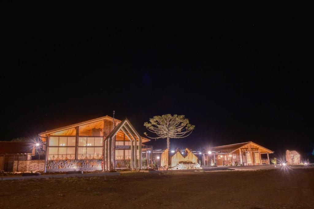 a building with a tree in front of it at night at Vistas de Mantiqueira in Bom Jardim da Serra