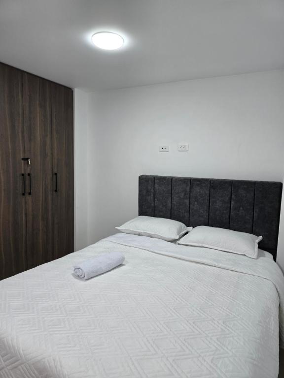 ein Schlafzimmer mit einem großen Bett mit zwei weißen Kissen in der Unterkunft Posada Los Geranios in Duitama