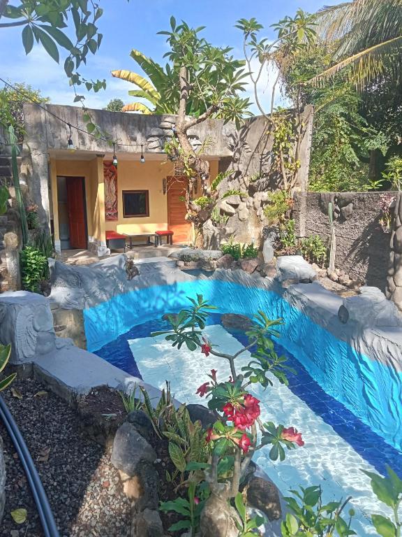 a swimming pool in front of a house at ATB Hostel in Lovina