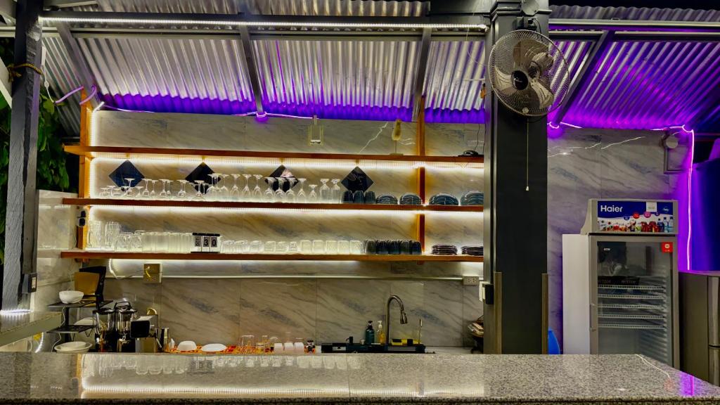a kitchen with a counter with glasses on a shelf at Nowhere Siqujor Hostel in San Juan
