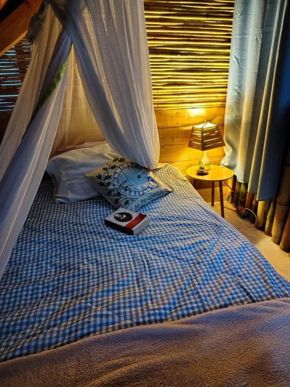 a bed with a book sitting on top of it at Cabaña HobbitXoxo in Xoxocotla