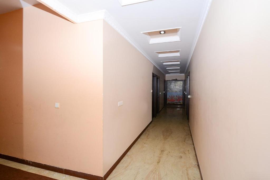 Hotel O Samar Palace في جايبور: ممر فارغ بجدران بيضاء وسقف