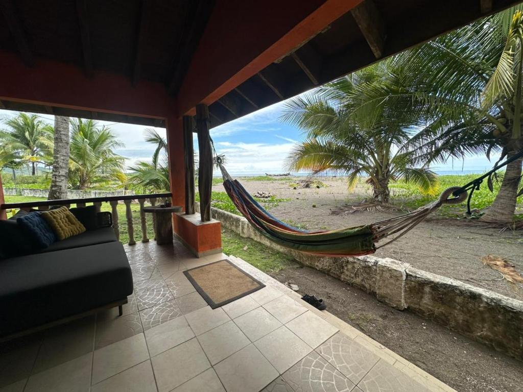 a hammock in a room with a view of the beach at Venao Beachfront Cabana in Playa Venao