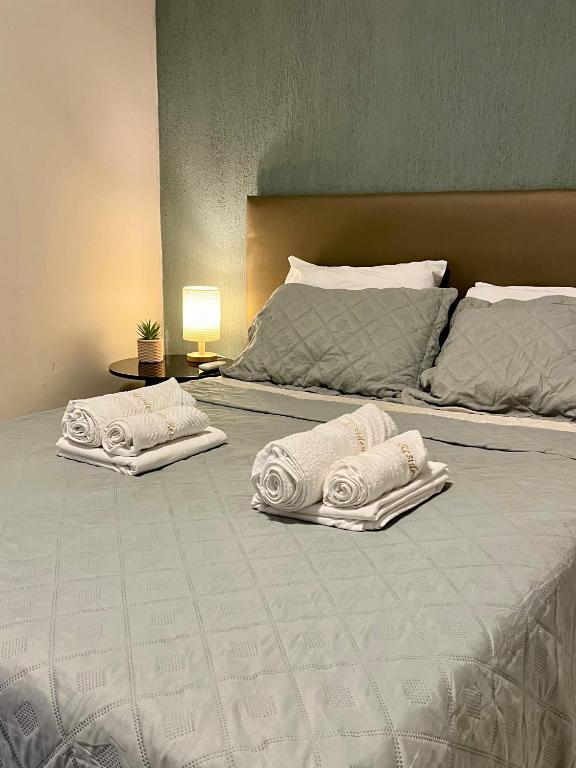 two beds with towels sitting on top of them at Apto Exclusivo a 30m da Praça da Sé - Norões Residence in Crato