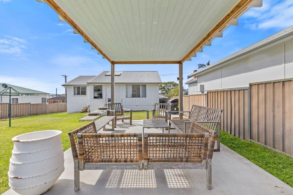 een patio met 2 banken en een hek bij Harbour Mist Hideaway - Where Coast Meets Calm in Ulladulla