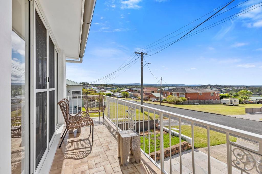 Un balcón con un banco y vista a una calle. en Harbour Mist Hideaway - Where Coast Meets Calm, en Ulladulla