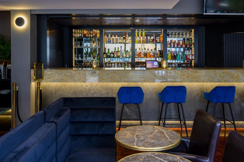 a bar with blue chairs and a counter with drinks at Crest on Barkly Hotel in Melbourne