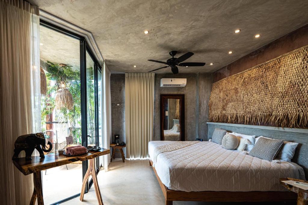 a bedroom with a bed and a ceiling fan at Xkeban Tulum Adults Only in Tulum