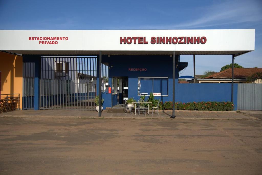 a building with a h hotel singapore sign on it at Hotel Sinhozinho in Coxim