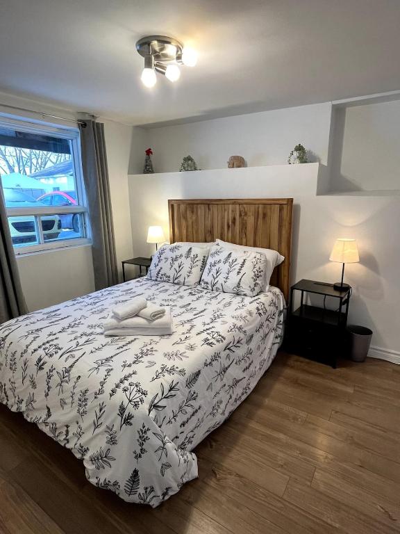a bedroom with a bed with a white comforter and a window at La Suite Centre-ville Saint-Georges in Saint-Georges