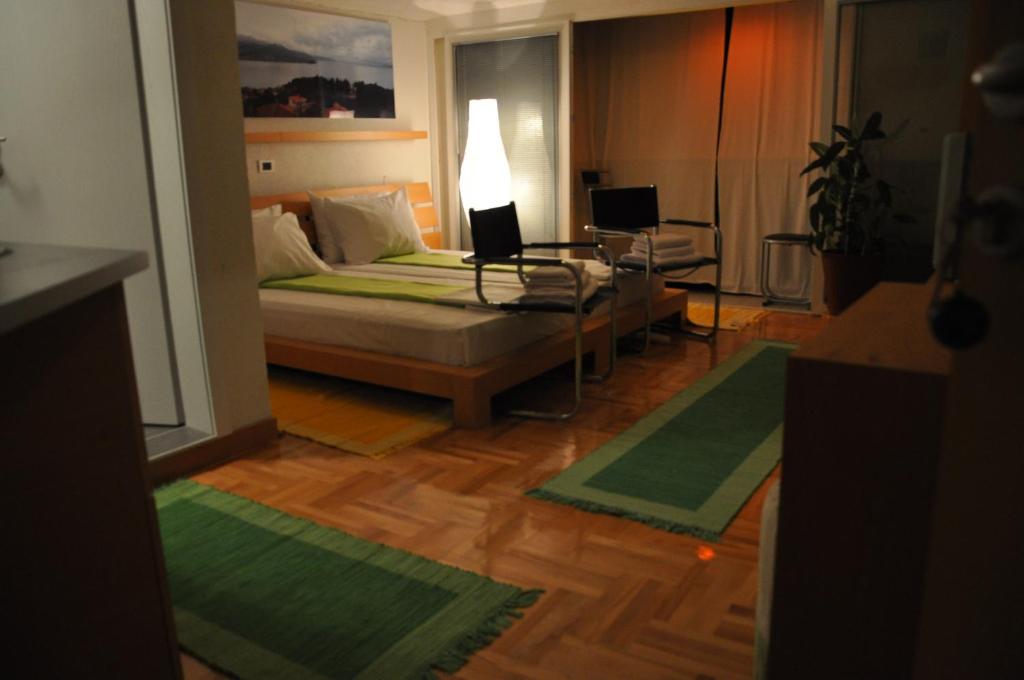 una camera con un letto e un tavolo e due tappeti di Modern Studios in Ohrid a Ohrid