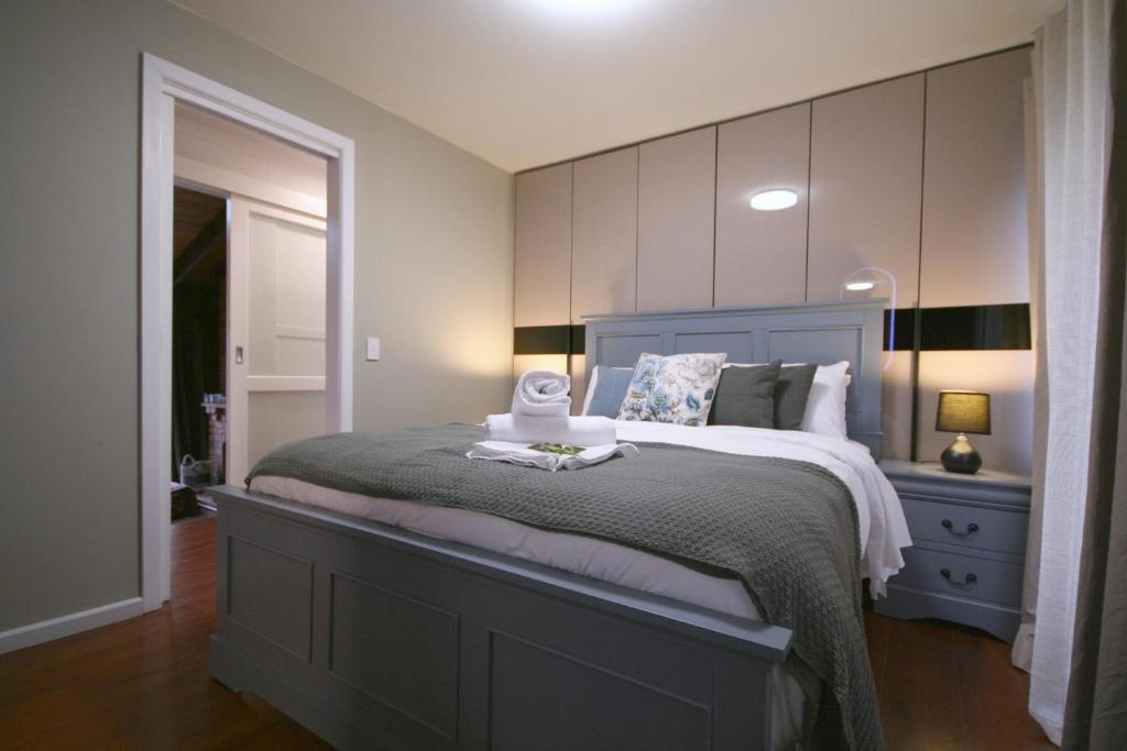 Un dormitorio con una cama grande con cabecero azul. en Rezara House - 1 to 4 bedroom house, en Upwey