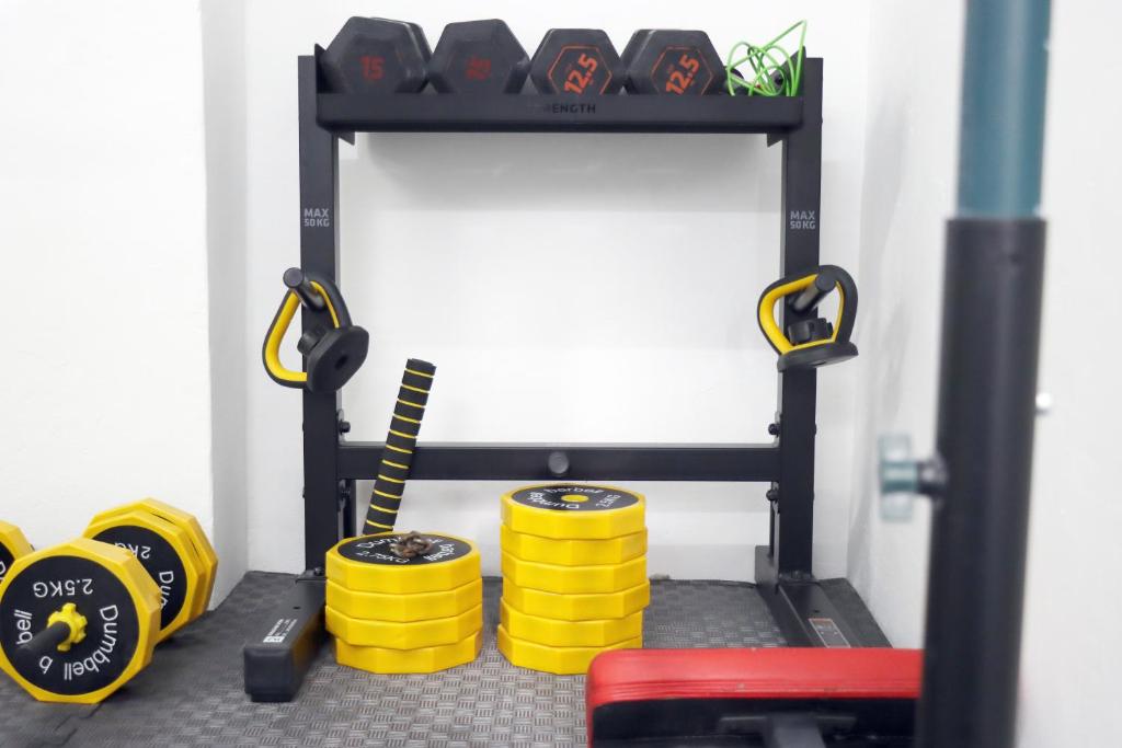 A compact strength-training station with kettlebells, weight plates and dumbbells.