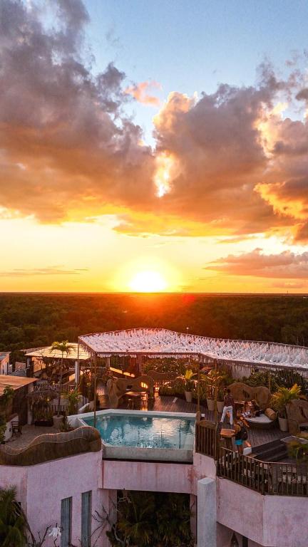 a view of a resort with a pool and the sunset at Xkeban Adults-Only Weekend Party in Tulum